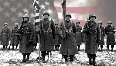 black and white photo of soldiers of the 442nd Regimental Combat Team standing in row. The soldiers in the front row are carrying flags. Behind the soldiers is a color image of the US flag